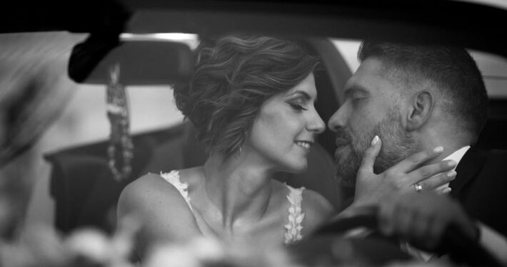 Κοντινή ασπρόμαυρη φωτογραφία του γαμπρού και της νύφης που κοιτάζονται τρυφερά στα μάτια.