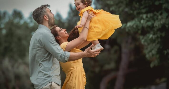 Ο πατέρας πετάει ψηλά το κοριτσάκι του κατά τη διάρκεια οικογενειακής φωτογράφισης.
