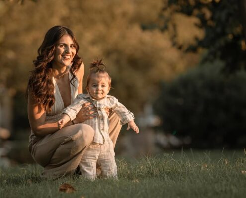 Οικογενειακό πορτραίτο στη φύση, με τη μητέρα να κρατάει το μωρό και τον πατέρα δίπλα τους.