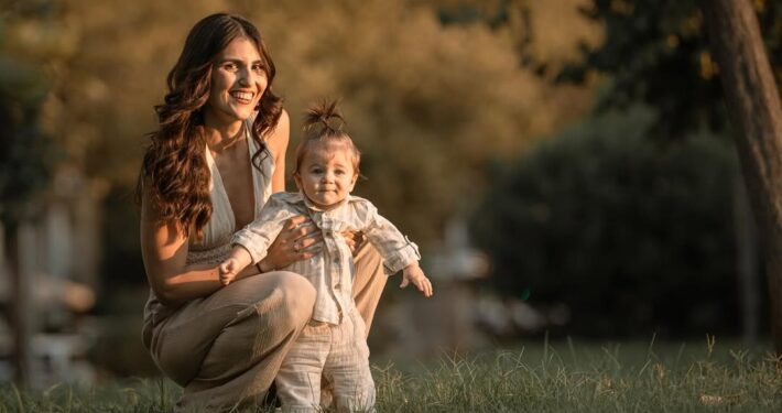 Οικογενειακό πορτραίτο στη φύση, με τη μητέρα να κρατάει το μωρό και τον πατέρα δίπλα τους.