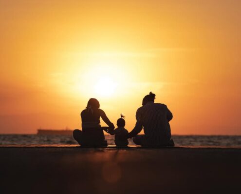 Καλλιτεχνική φωτογραφία με τις σιλουέτες μιας οικογένειας μπροστά στο ηλιοβασίλεμα.