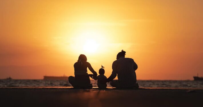 Καλλιτεχνική φωτογραφία με τις σιλουέτες μιας οικογένειας μπροστά στο ηλιοβασίλεμα.