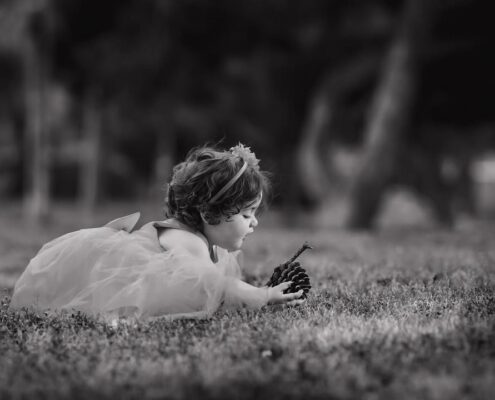 Ασπρόμαυρη καλλιτεχνική φωτογραφία μικρού παιδιού που παίζει στο γρασίδι.
