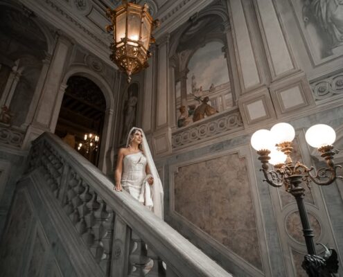 Ευρεία λήψη της νύφης στην εντυπωσιακή σκάλα ενός ιστορικού νεοκλασικού κτιρίου.