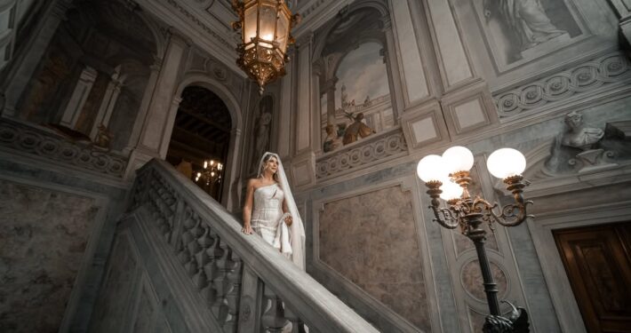 Ευρεία λήψη της νύφης στην εντυπωσιακή σκάλα ενός ιστορικού νεοκλασικού κτιρίου.