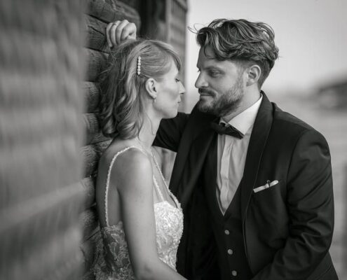 Τρυφερή ασπρόμαυρη φωτογραφία του γαμπρού και της νύφης που κοιτάζονται στα μάτια.