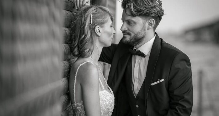 Τρυφερή ασπρόμαυρη φωτογραφία του γαμπρού και της νύφης που κοιτάζονται στα μάτια.