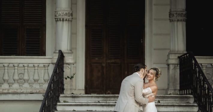 Ρομαντική στιγμή του ζευγαριού στα σκαλιά ενός επιβλητικού ιστορικού κτιρίου.