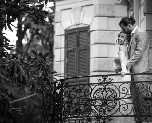 Ασπρόμαυρη φωτογραφία του ζευγαριού σε μπαλκόνι κτιρίου με νεοκλασική αισθητική.
